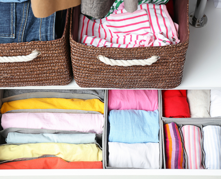 Ubrania starannie poukładane w szufladach i koszach – inspiracja do rozpoczęcia małych porządków w garderobie.